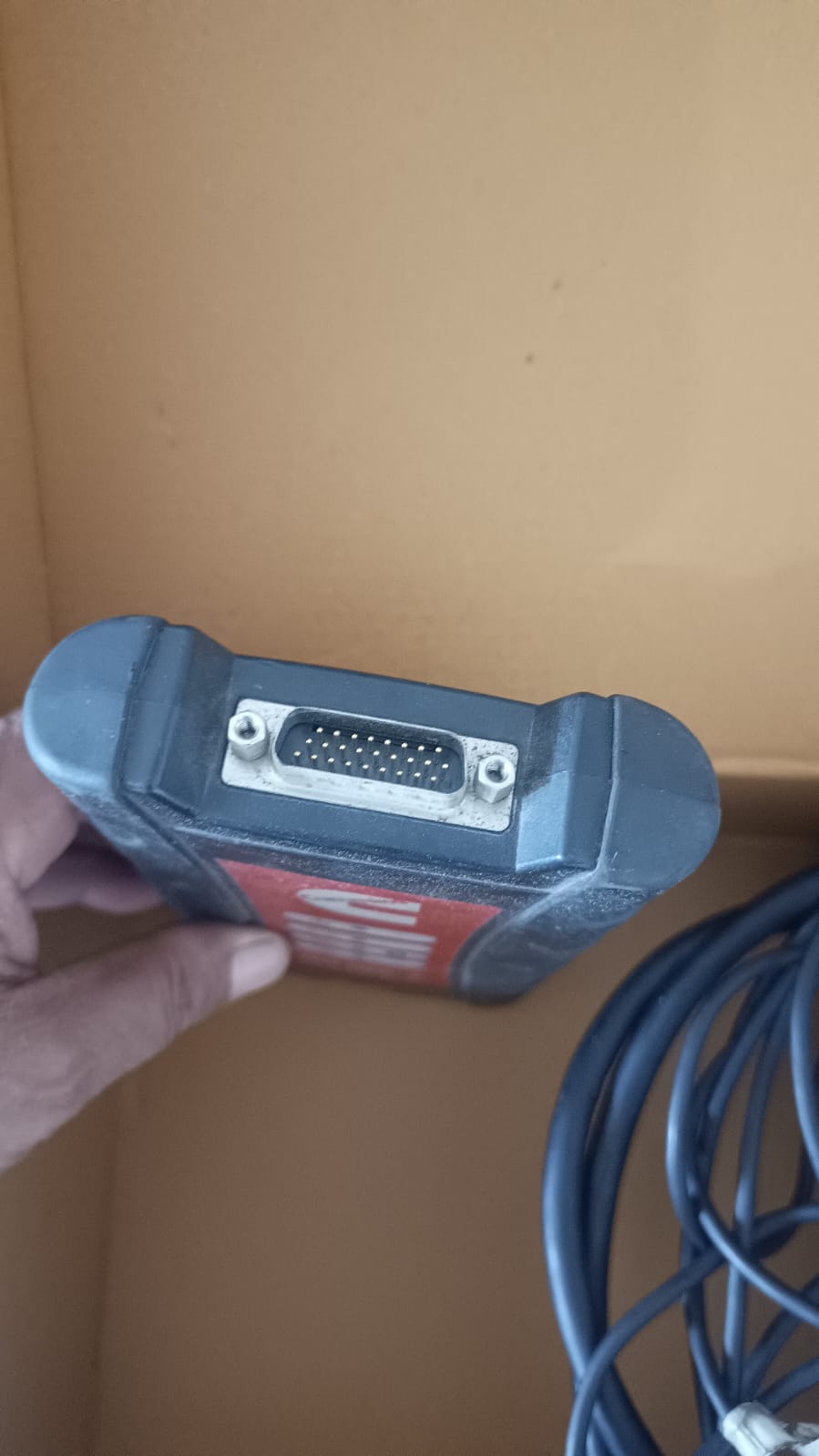 Blue diagnostic tool with a cable on a brown background